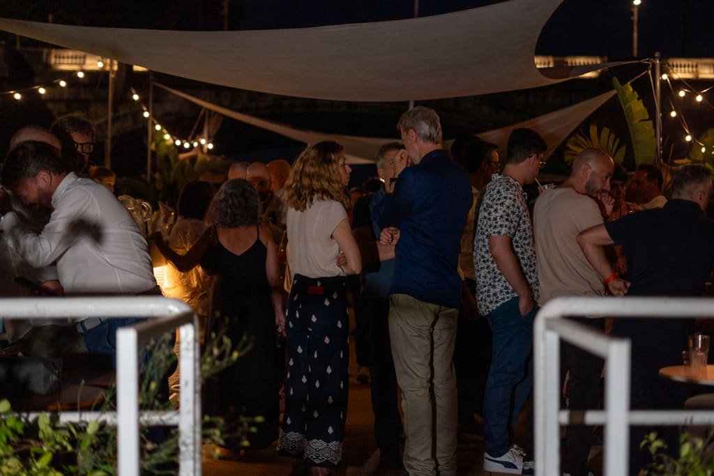Ospiti in terrazza sotto le tende a vela durante un evento serale